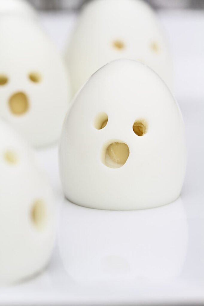 spooky boiled eggs. hard cooked eggs made to look a little creepy with a face carved out.