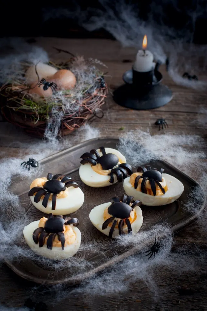 deviled eggs for Easterween with spooky candle and cobwebs in background