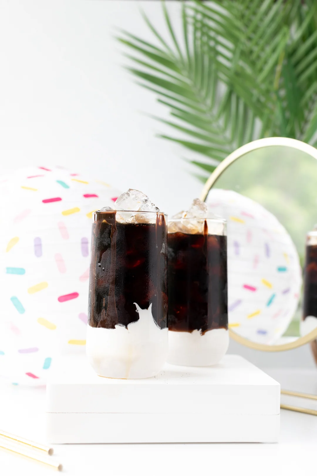 black cold brew iced coffee poured over frozen whipped cream in glasses