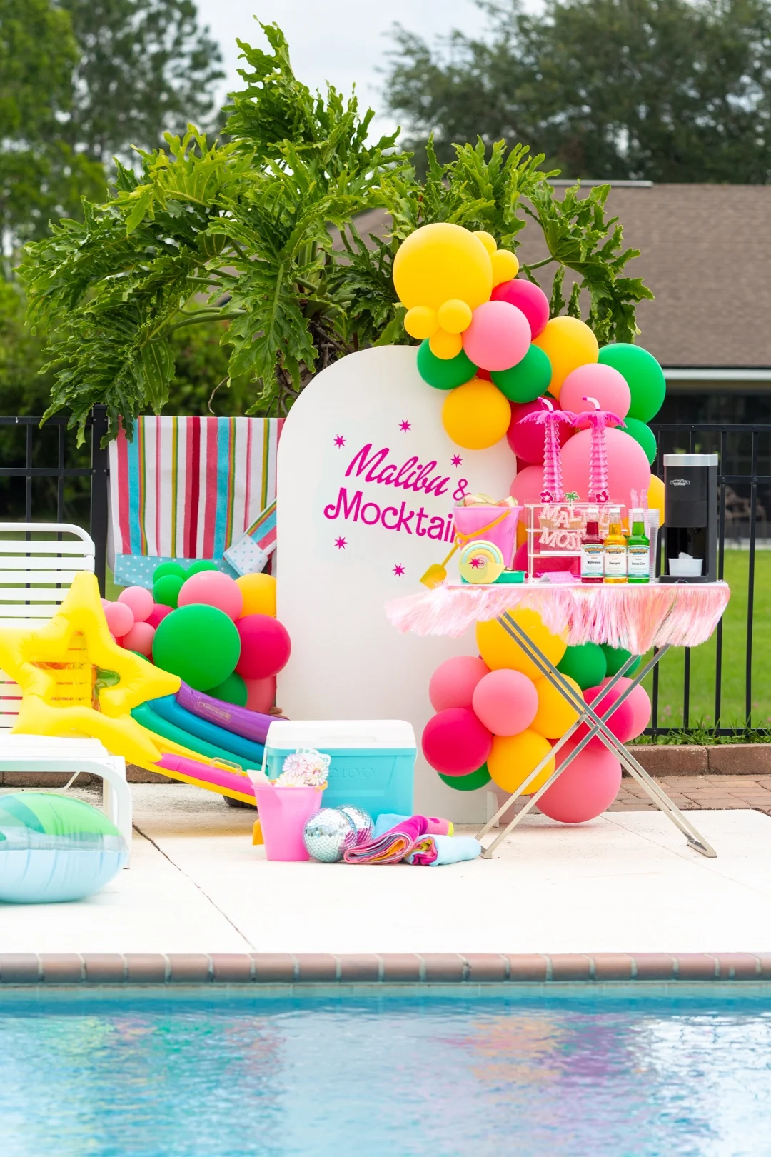 gorgeous malibu pool party theme with barbie font, big balloons and party floats.