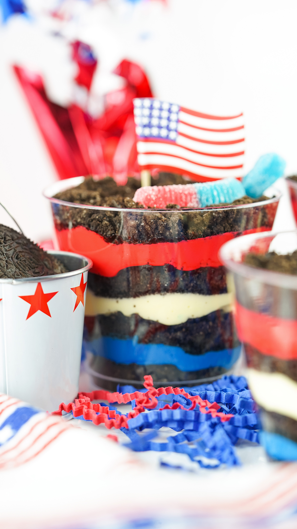 up close view of patriotic dirt cups with red, white and blue layers of pudding and crushed oreos.
