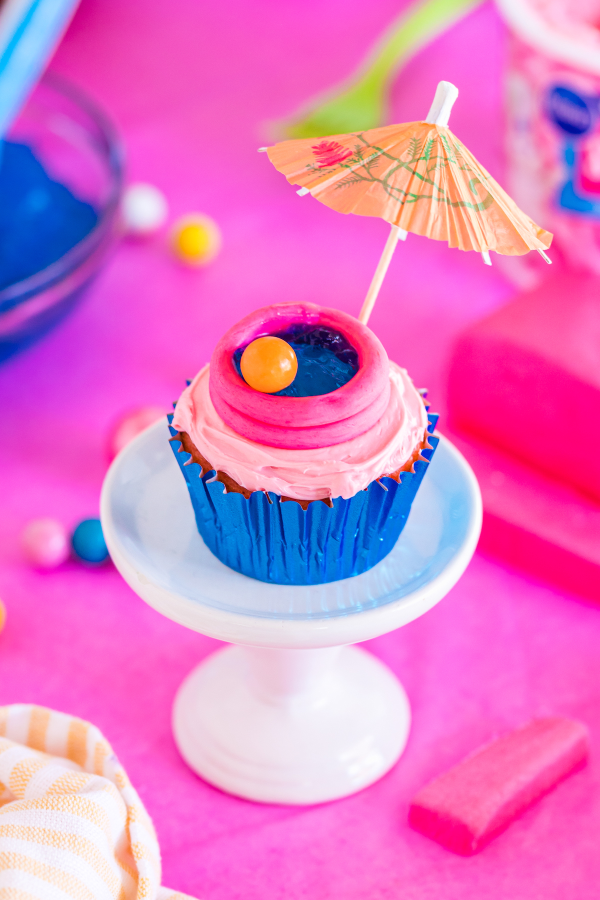 up close pool themed cupcake with cocktail umbrella and gum beach ball.