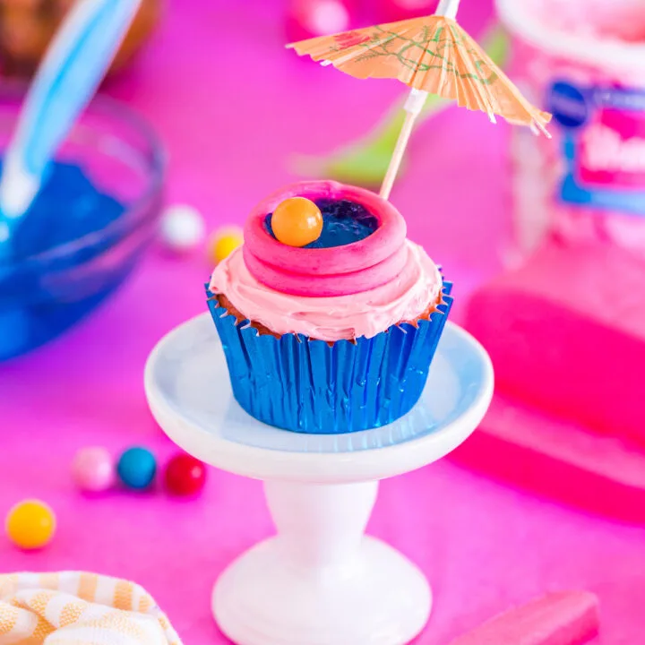 pretty pool cupcake with an cocktail umbrella on a cupcake stand