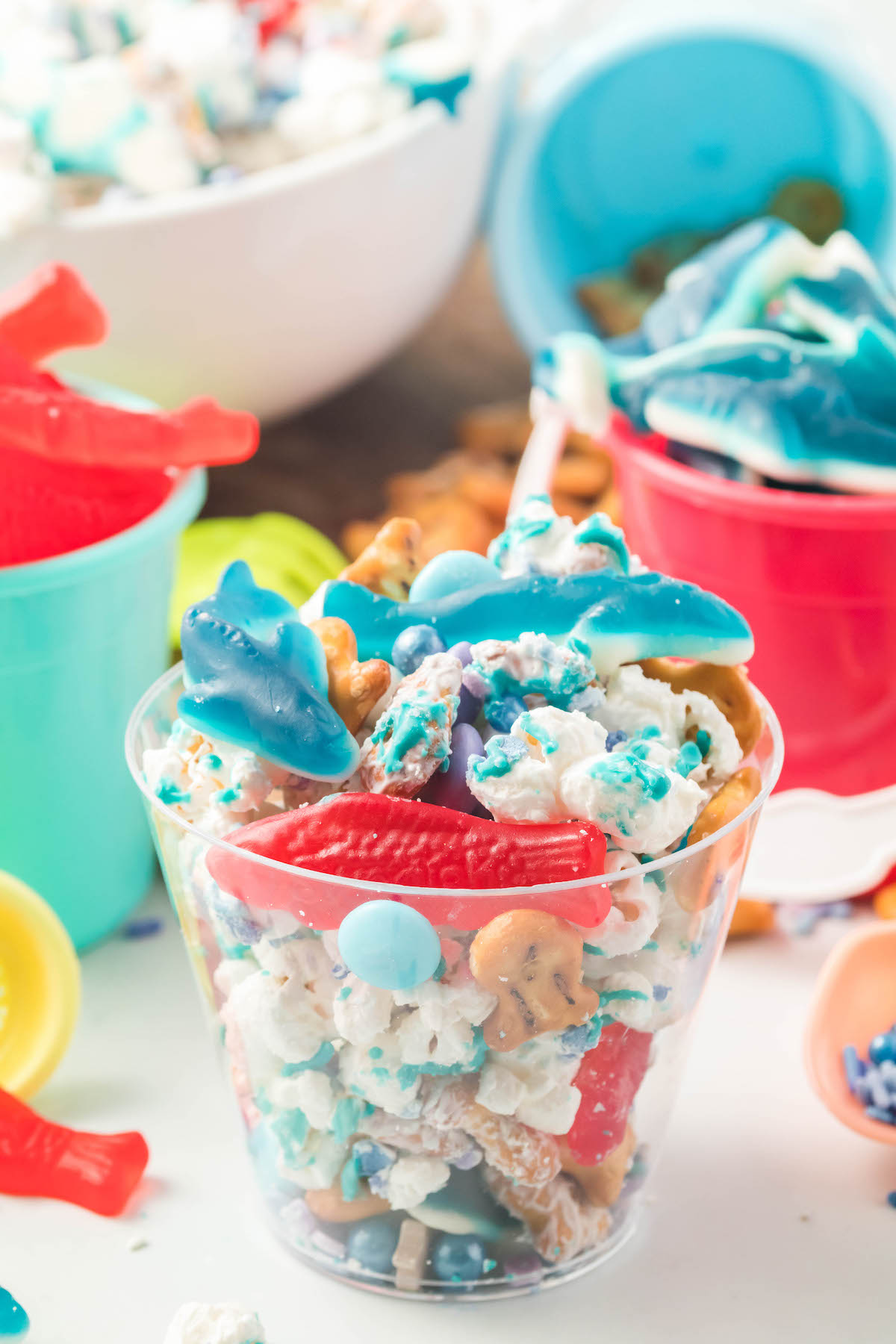 clear cups filled with shark bait snack mix with gummy sharks and swedish fishes.