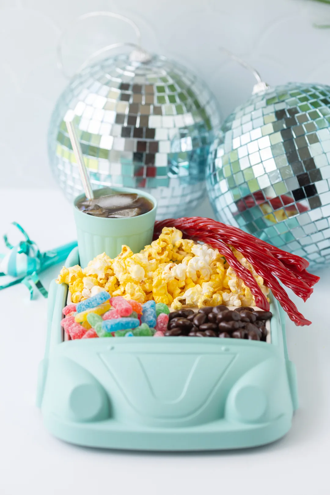 cute movie night snack tray shaped like a car. filled with popcorn, sour patch kids, raisinettes and rootbeer. 