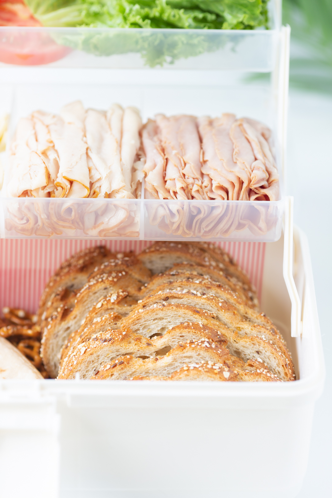 up close view of bread and lunch meat in a multi-tiered box