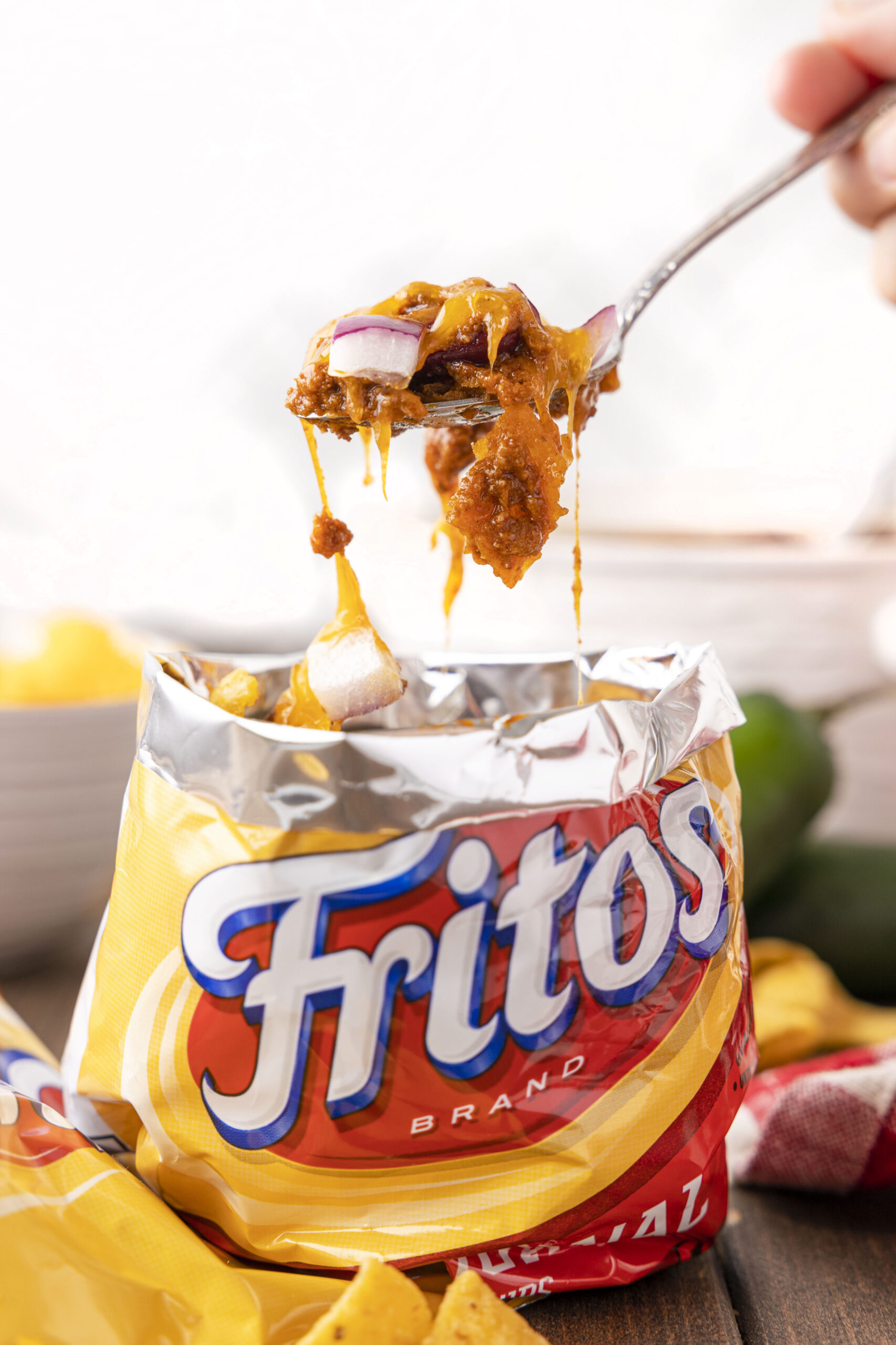 scoop of frito pie being scooped out of fritos bag