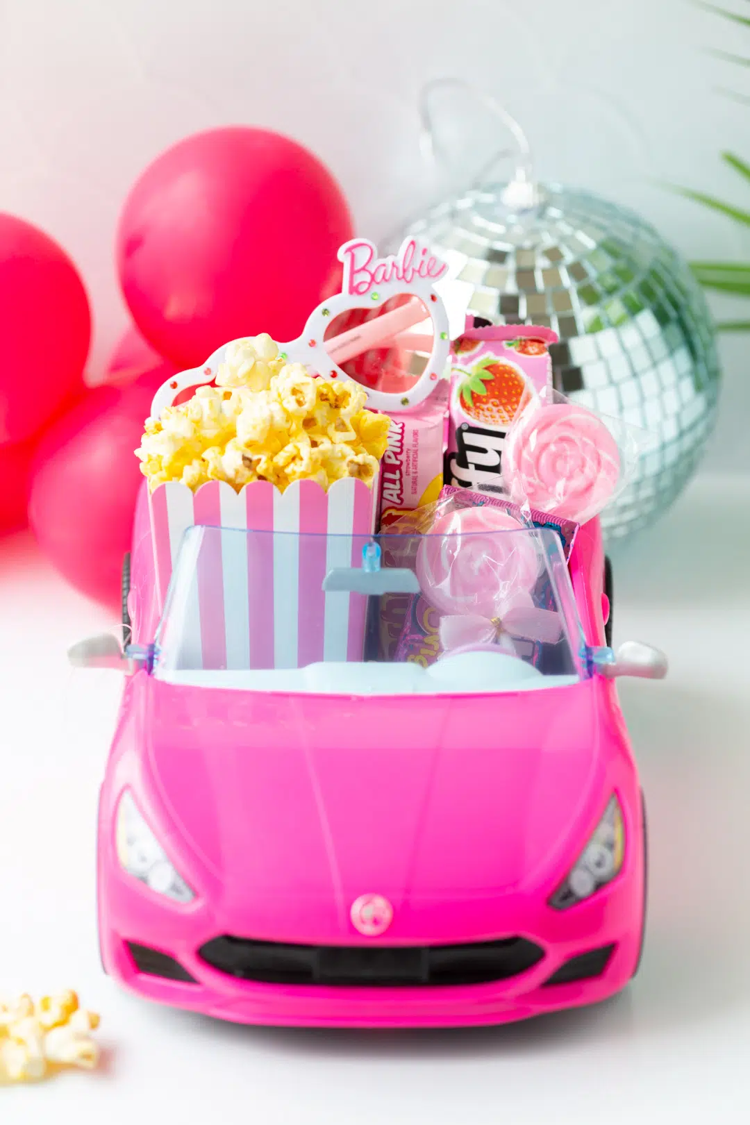 barbie doll pink convertible filled with movie night snacks