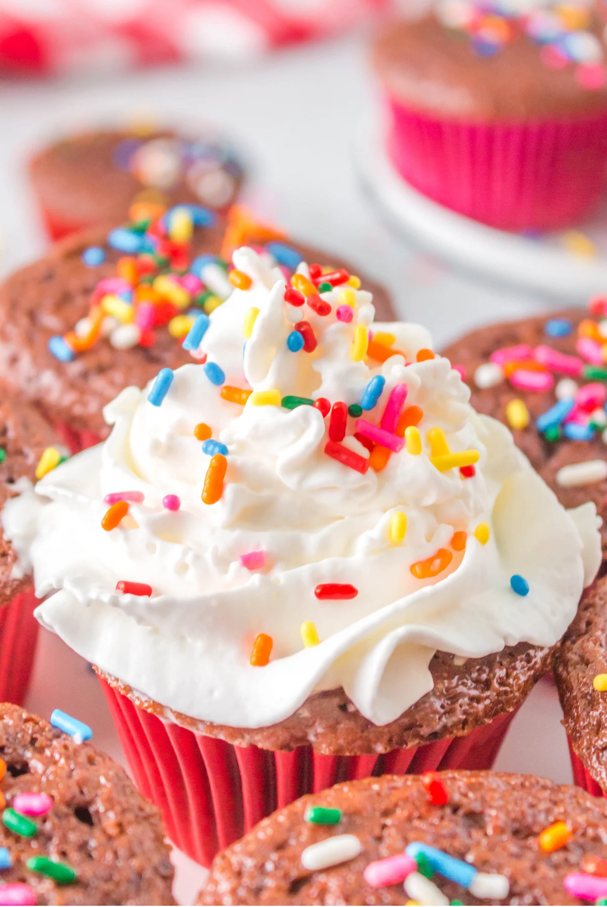 chocolate angel food cake cupcakes topped with whipped cream and sprinkles