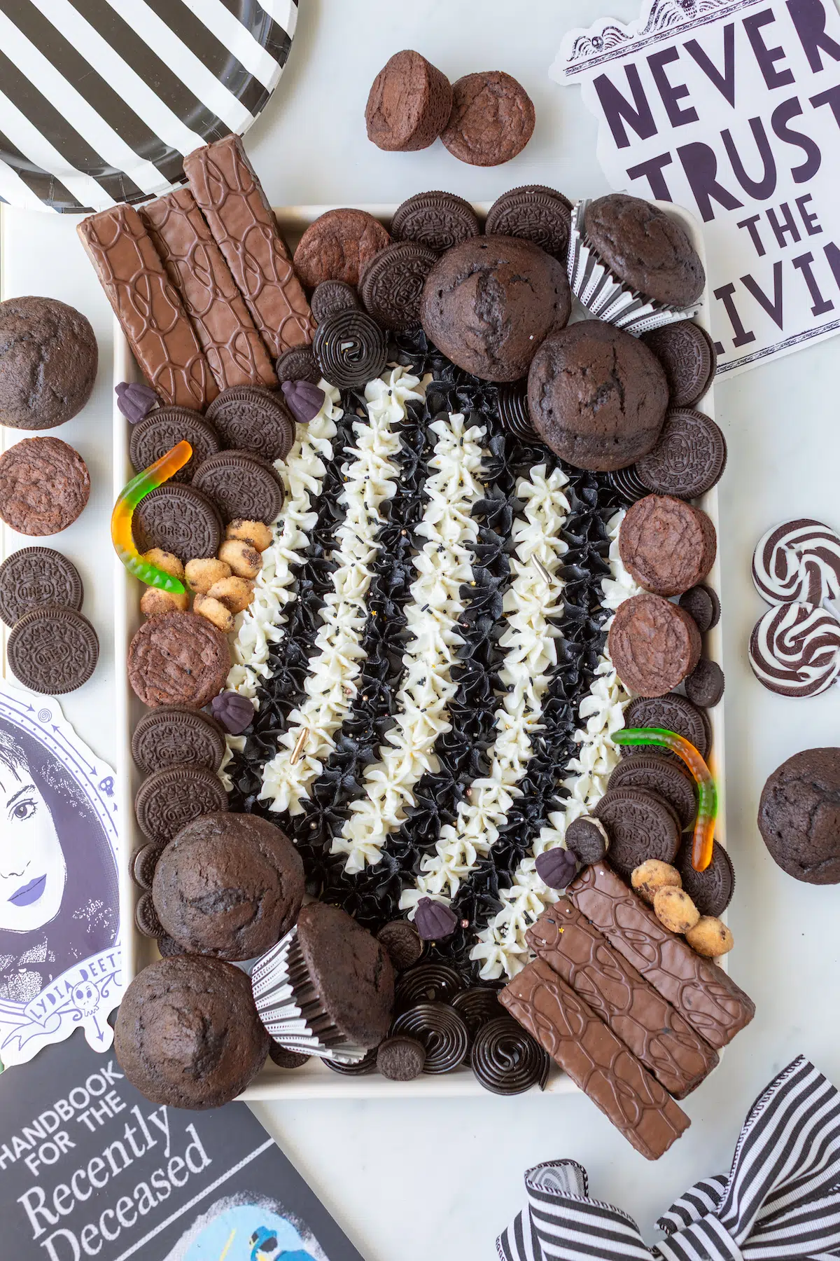 over the top view of buttercream board that is themed for beetlejuice movie