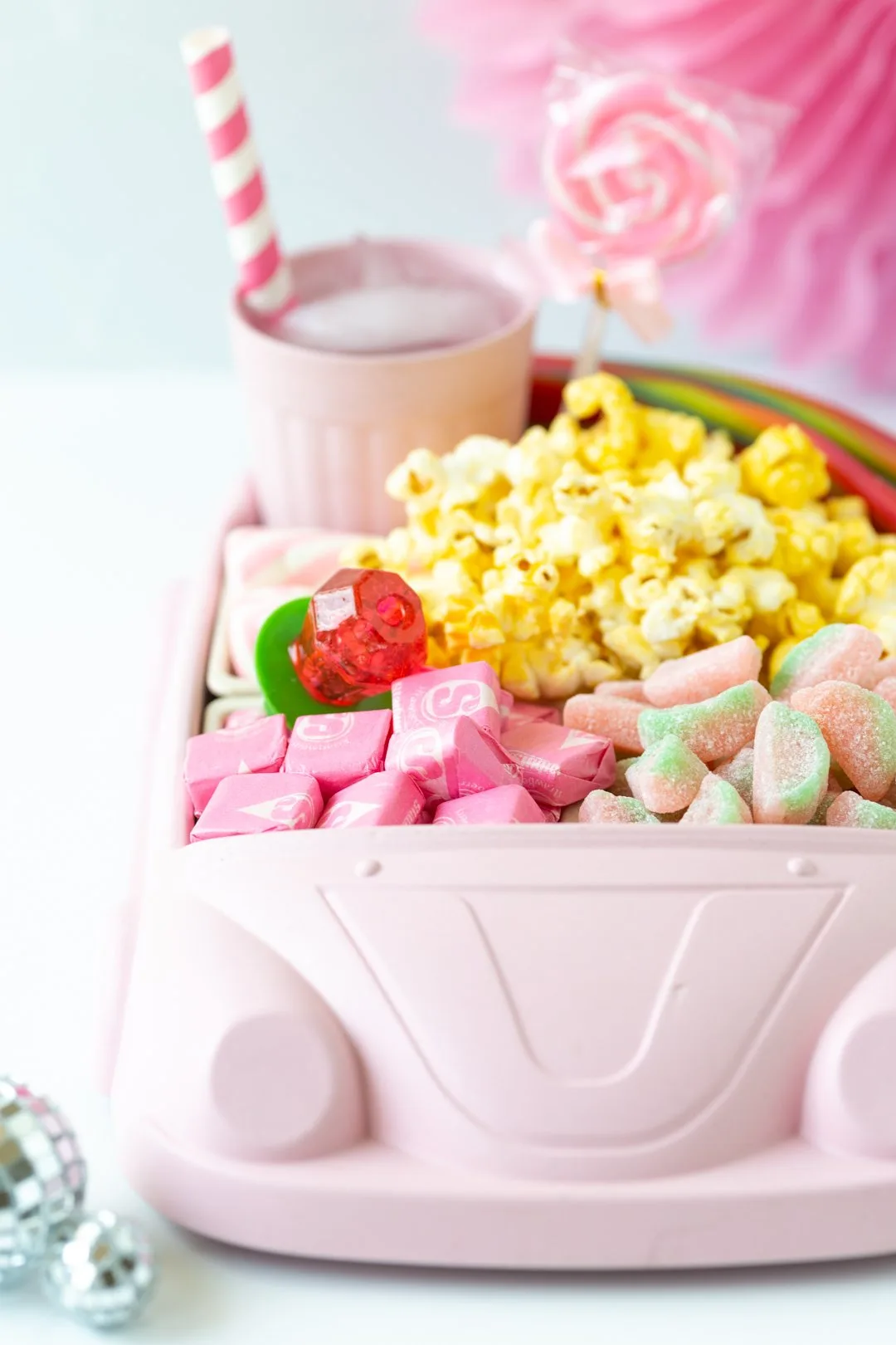adorable pink car tray used as a movie night in snack tray filled with popcorn and pink candies.