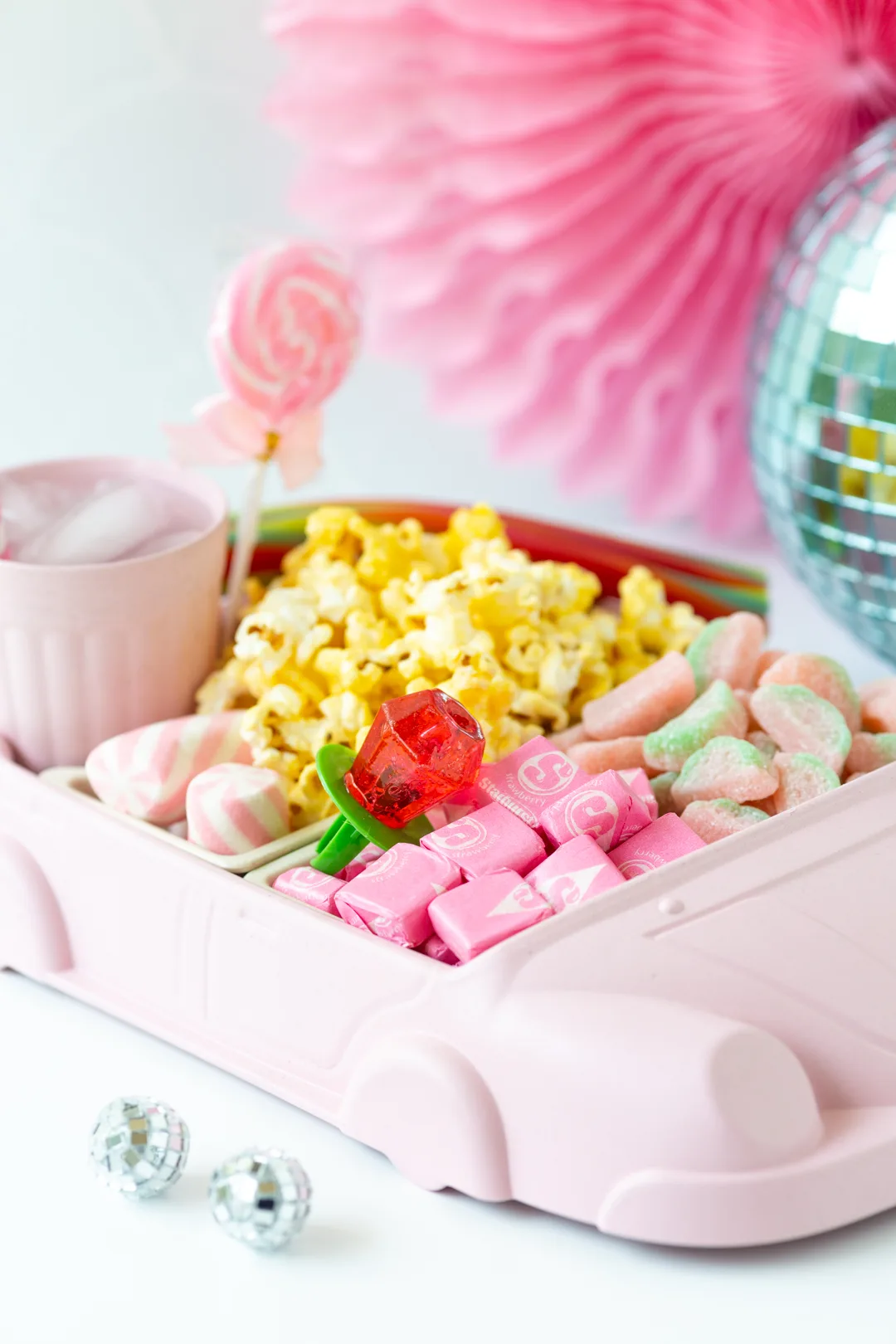 cute car movie night snack tray with popcorn, soda and pink candy in it.
