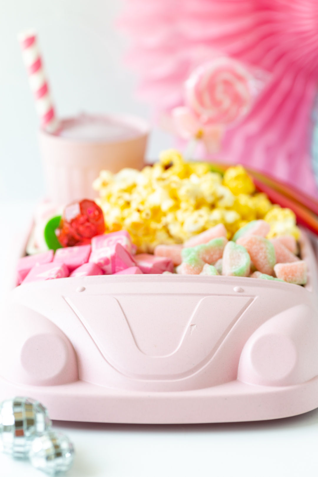 pink car shaped movie snack tray filled with pink candies and popcorn