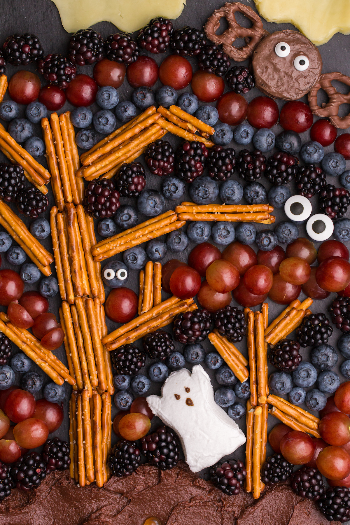 up close view of spooky forest charcuterie tray served on black slate cheeseboard