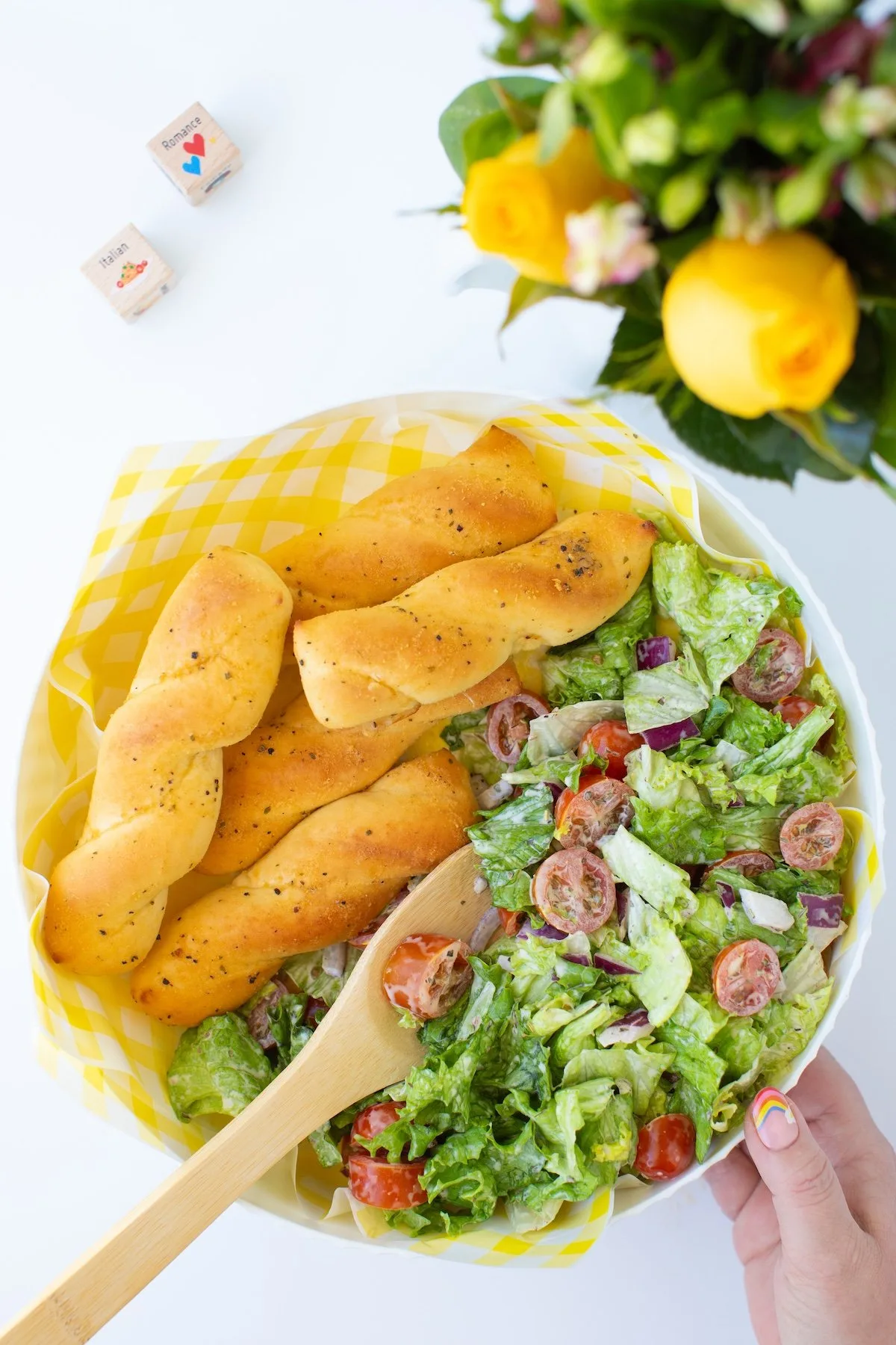dish filled with garlic bread sticks and green salad