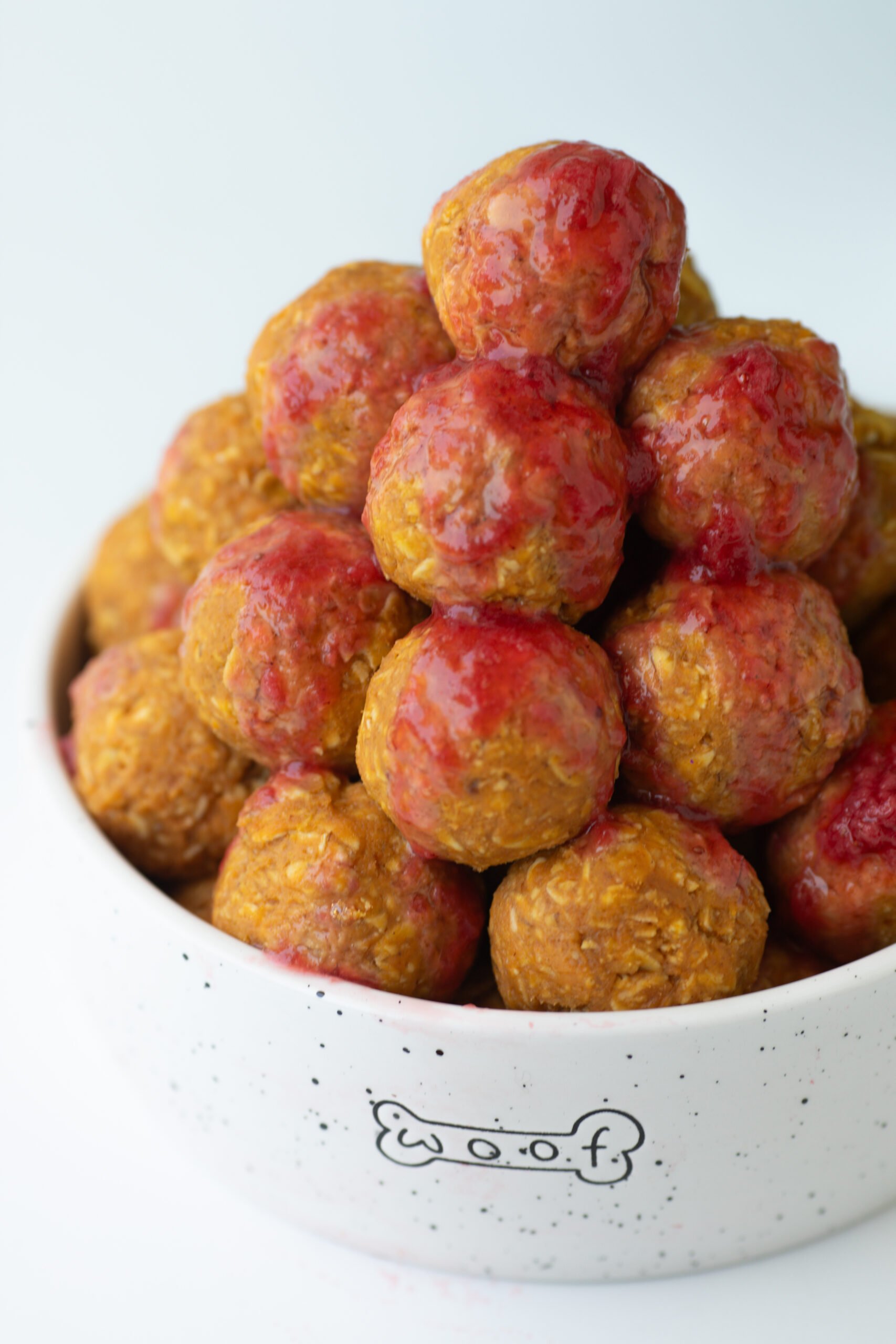 bowl of dog treats that look like meatballs but are made with oats, peanut butter and honey.