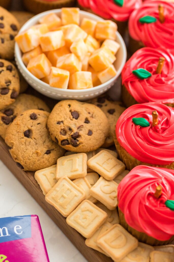 cookies, cheese and cupcakes on a dessert board