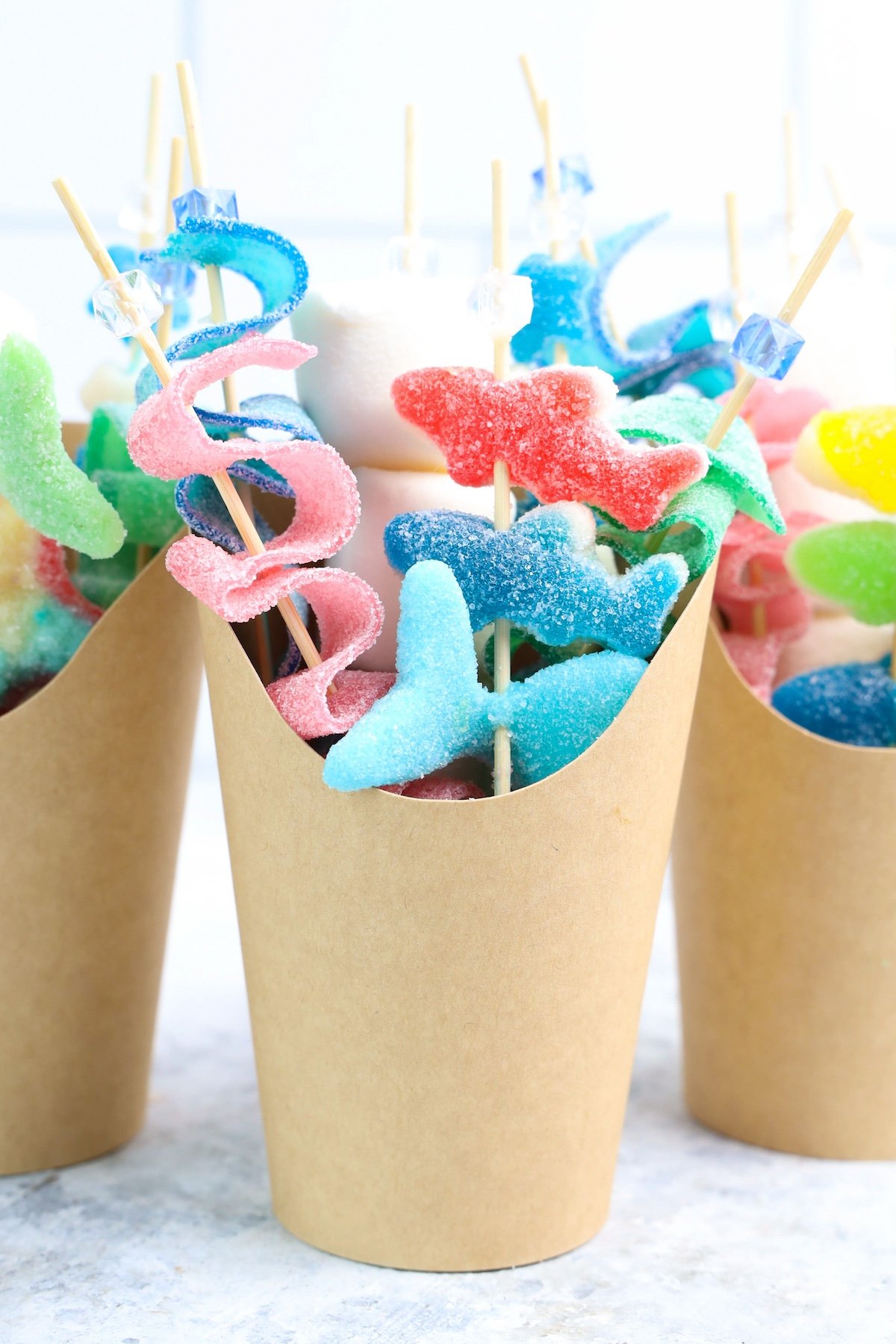 Beach Candy Charcuterie Cups with shark candies in a brown cup