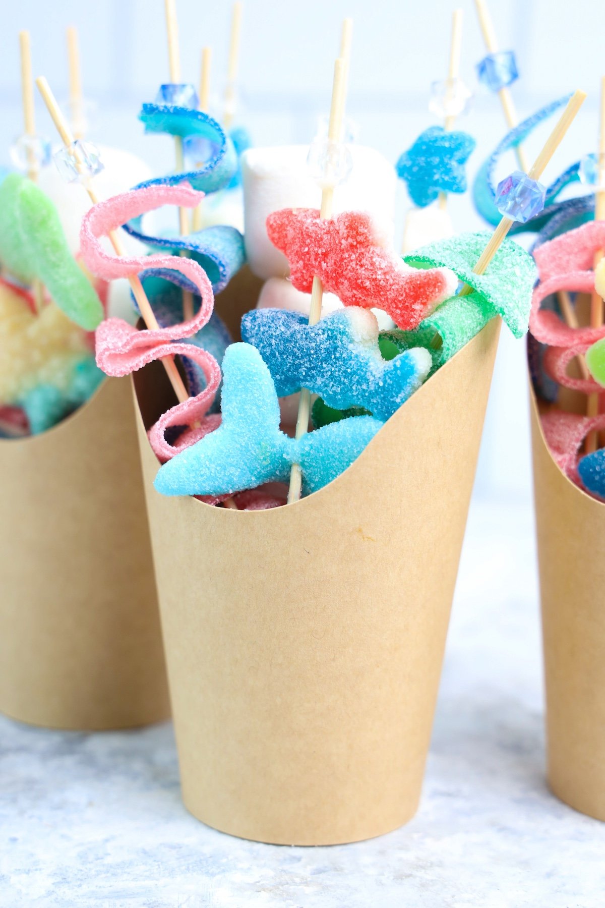 Beach Candy Charcuterie Cups with shark candies in a brown cup