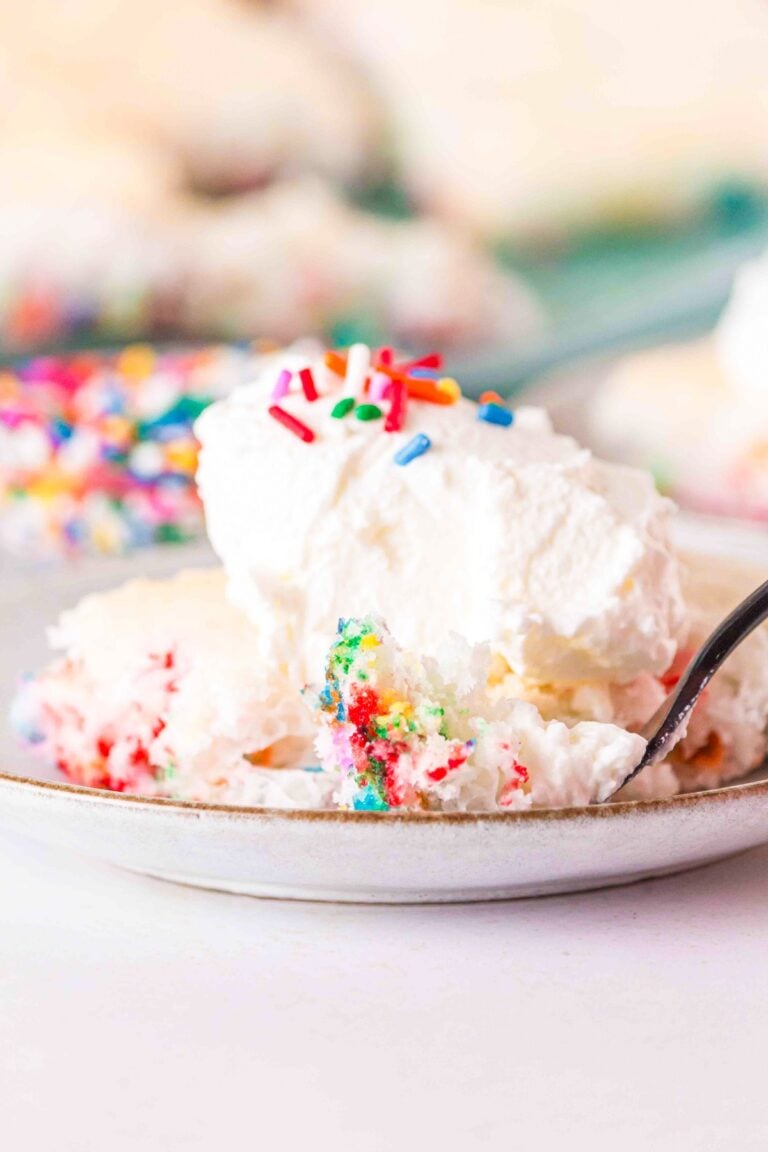 funfetti angel food sheet pan cake on a white plate with ice cream on top