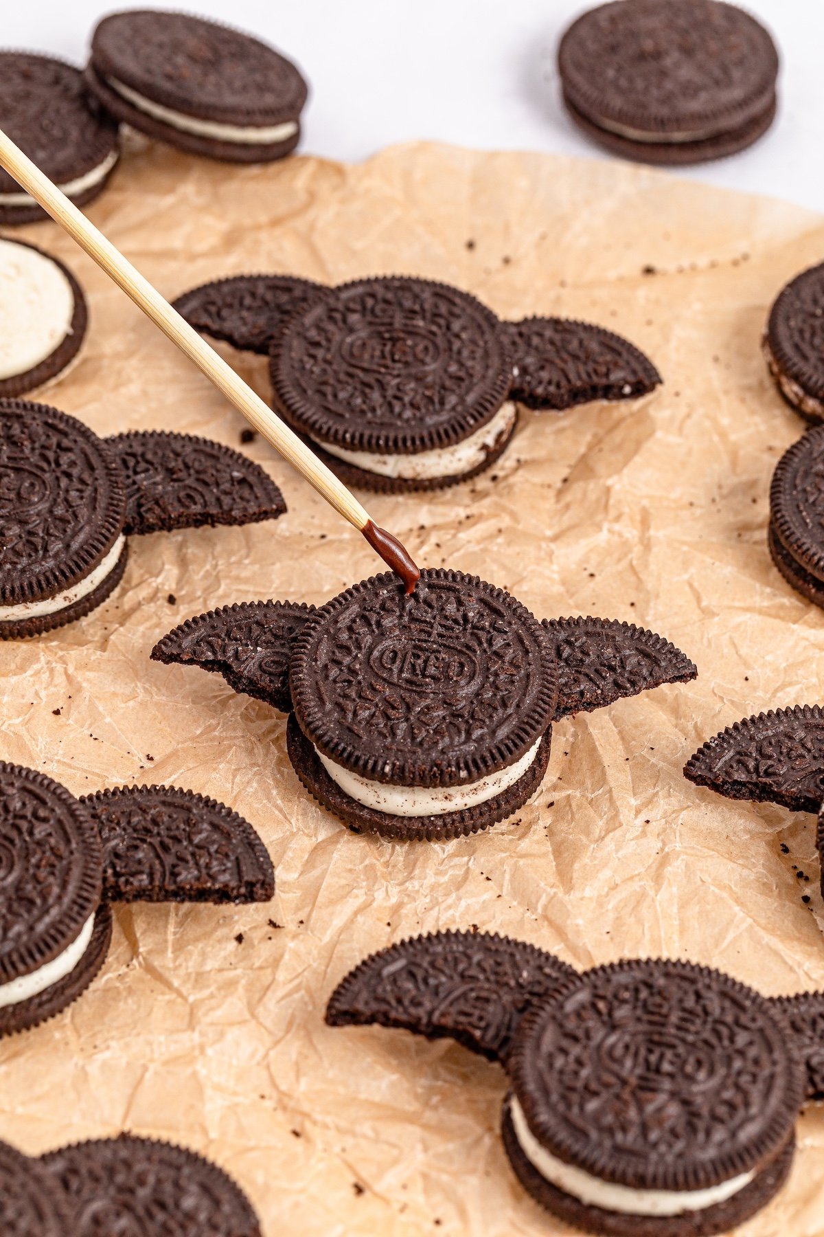 adding chocolate on top of the cookies with  skewer