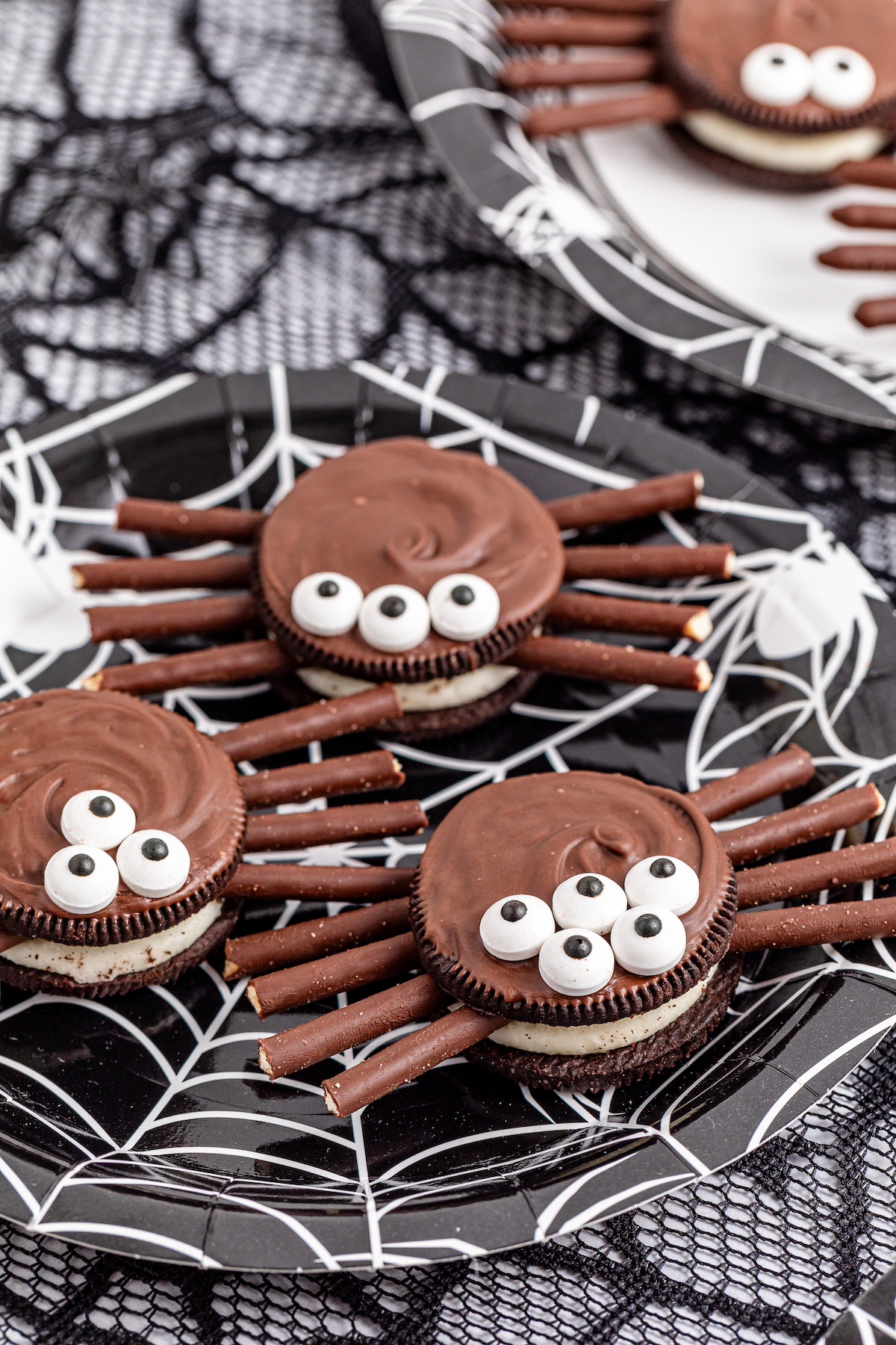 oreo spider cookies on a plate with webs