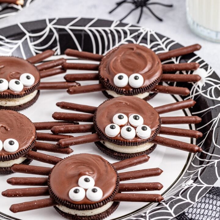 oreo spider cookies on a white plate with webs underneath