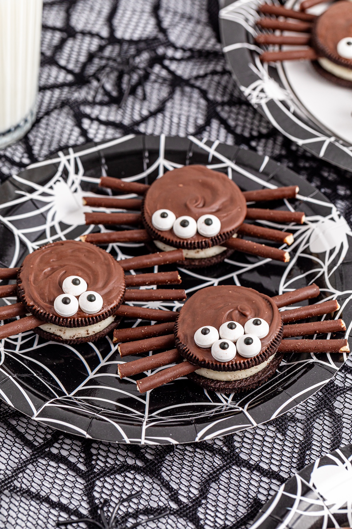 oreo spider cookies on a plate with webs