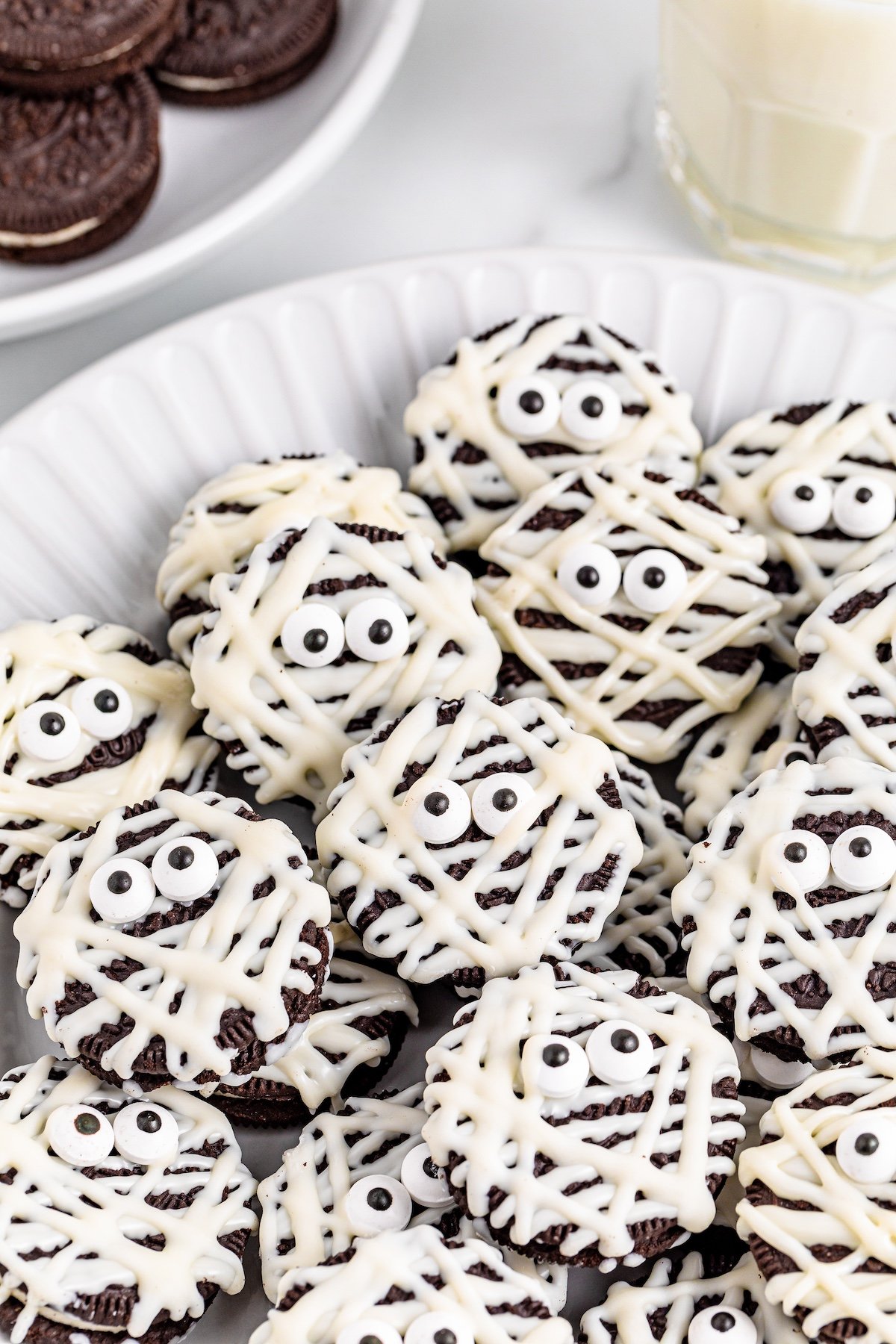 oreo mummies on a white plate with black web background