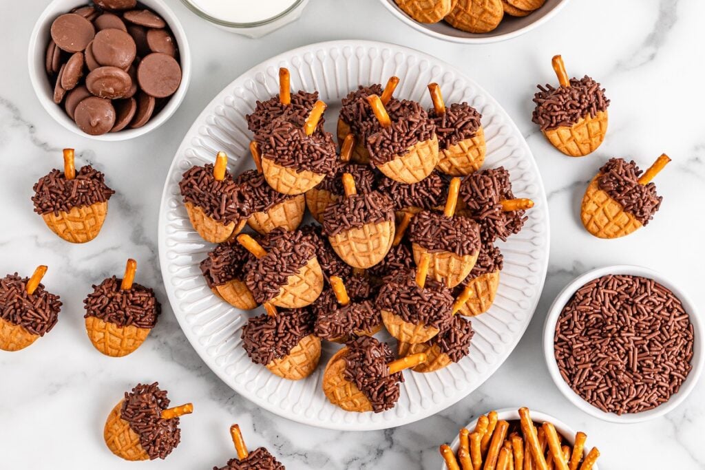 Nutter Butter Acorns, such a cute and easy autumn treat. Easy, no bake set on a white dish for serving.