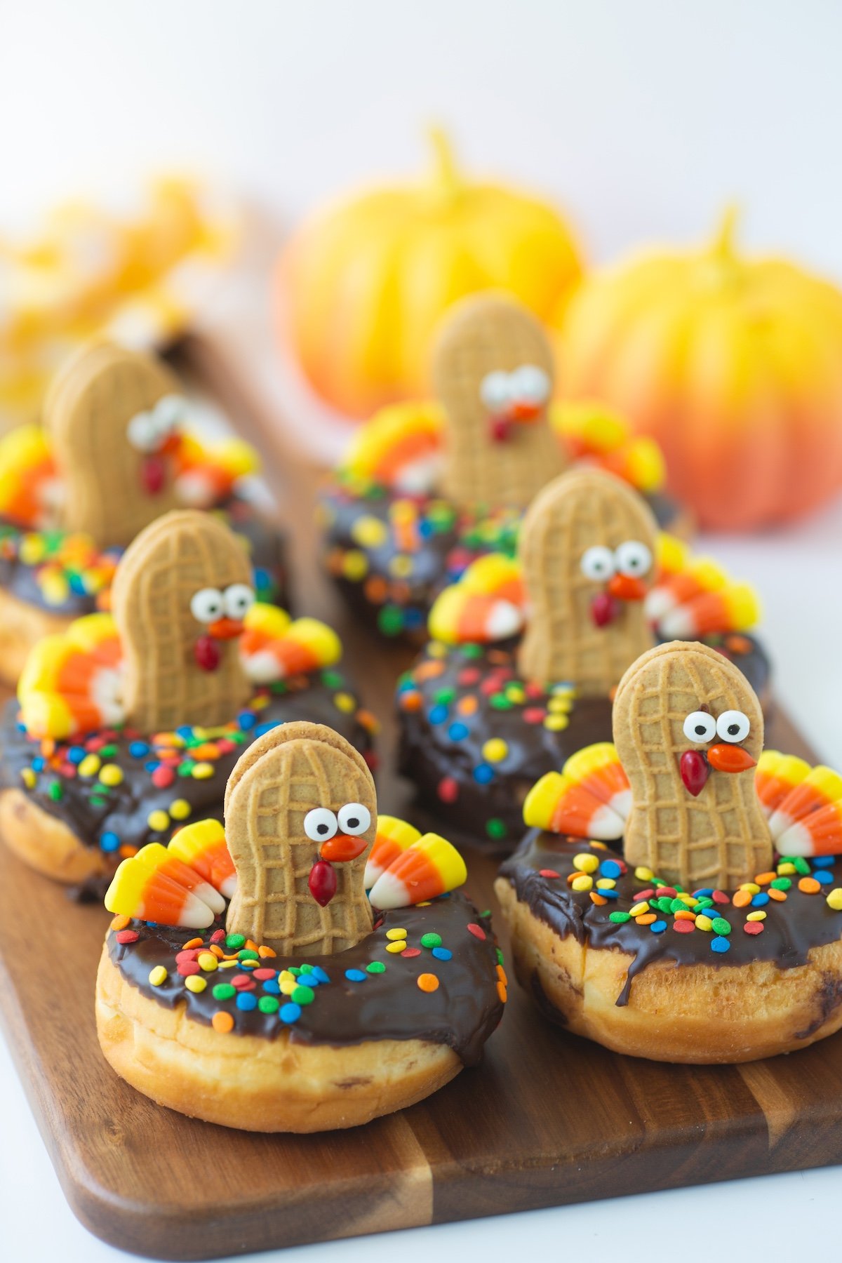 adorable turkey donuts served on a wooden tray.