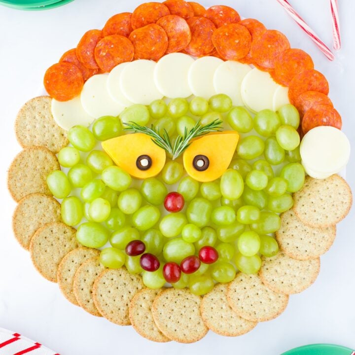 Grinch Cheese Tray with cheese, crackers, pepperoni and grapes.