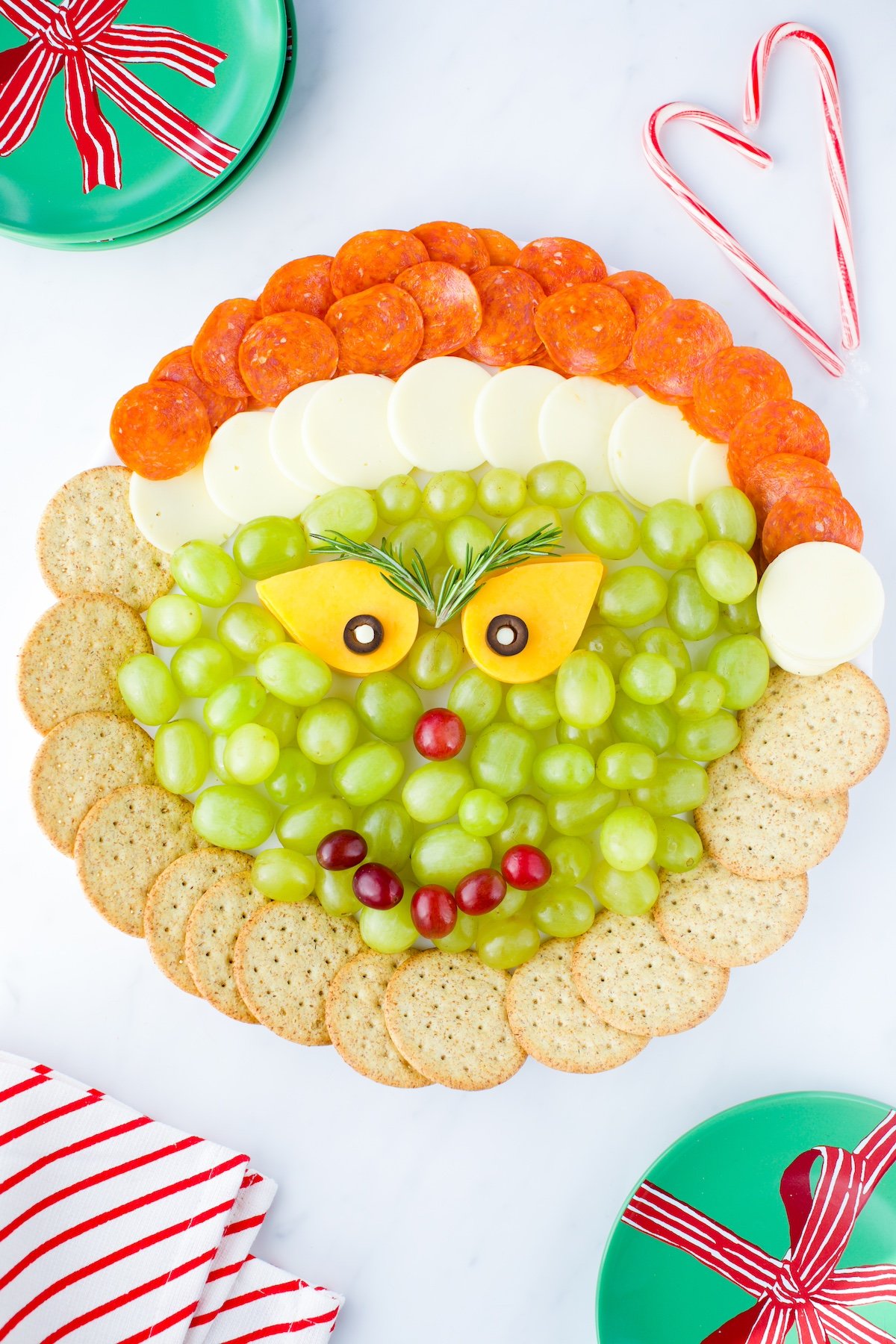 Grinch Cheese Tray with cheese, crackers, pepperoni and grapes.