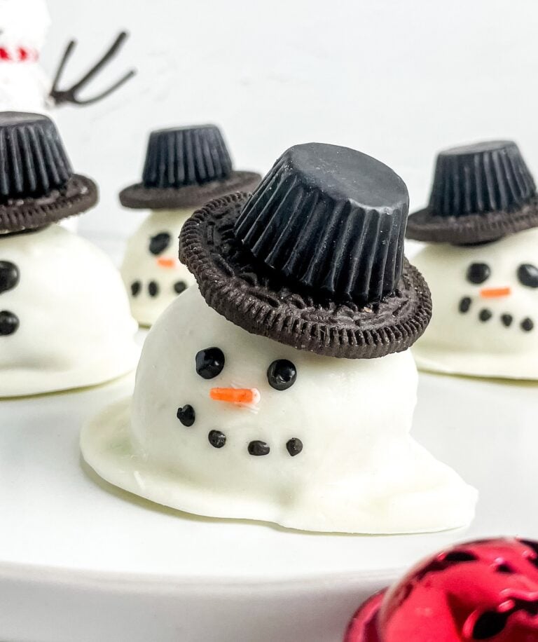 cute snowman truffles with top hats and a sprinkle nose.