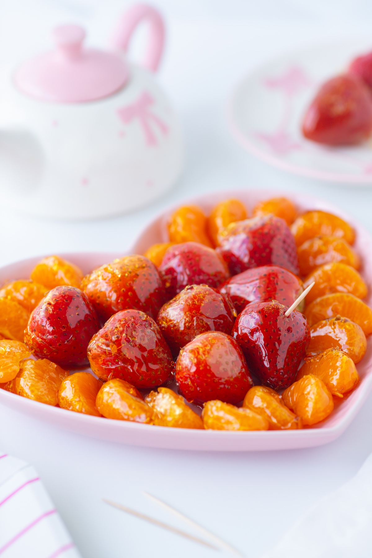 up close view of candied fruit snacks with strawberries and clementine sections that have been candied.