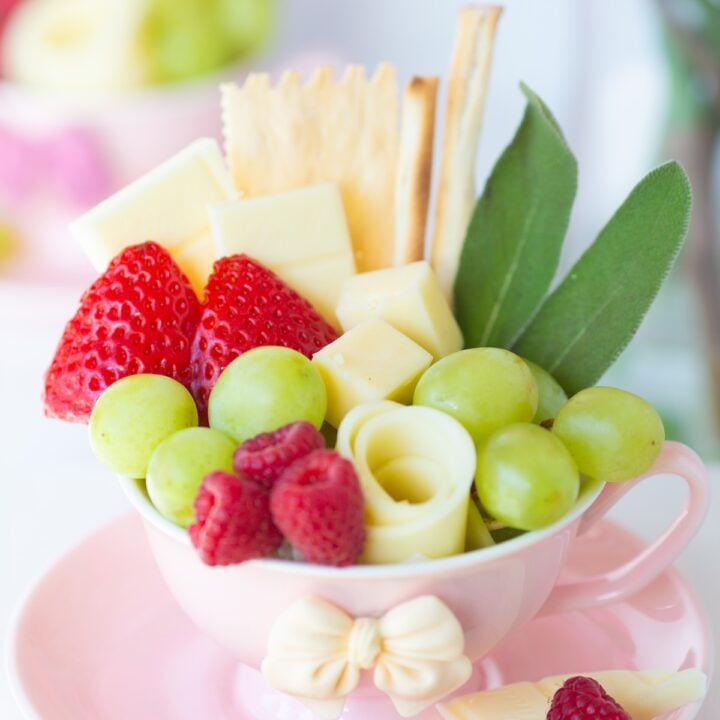 charcuterie tea cups with fruit, crackers and sweets. pretty bow teacups.