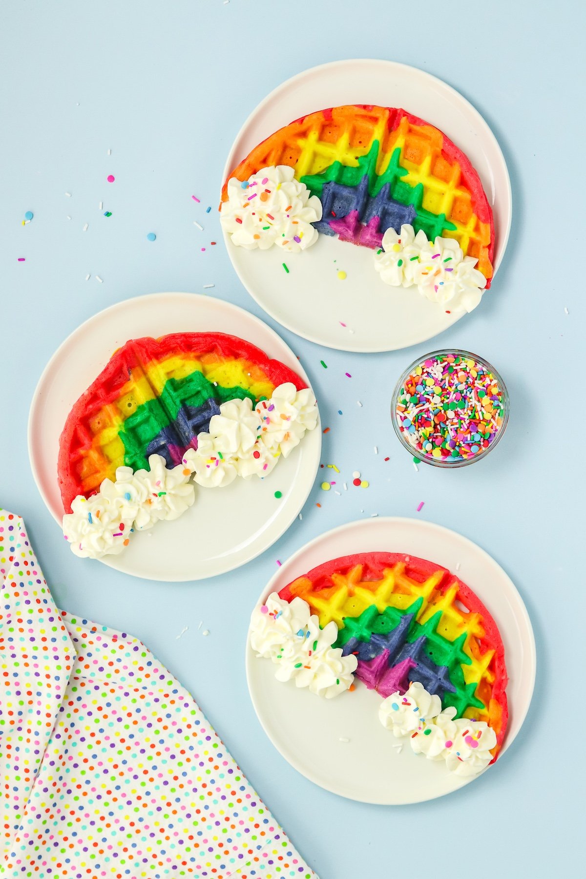 rainbow waffles on plates with sprinkes