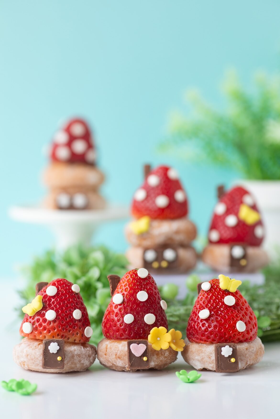 Cute smurf hut village made of strawberries, sprinkles, mini donuts and chocolate.