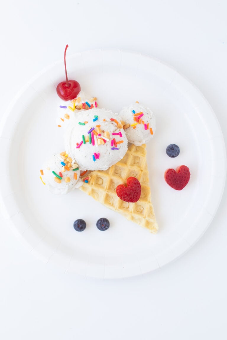 ice cream waffle sundae with cherry on top served on a plate