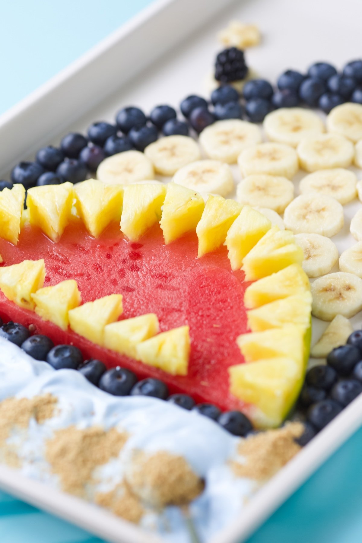 Side view of shark fruit platter with a watermelon slice mouth with teeth made with pineapple.