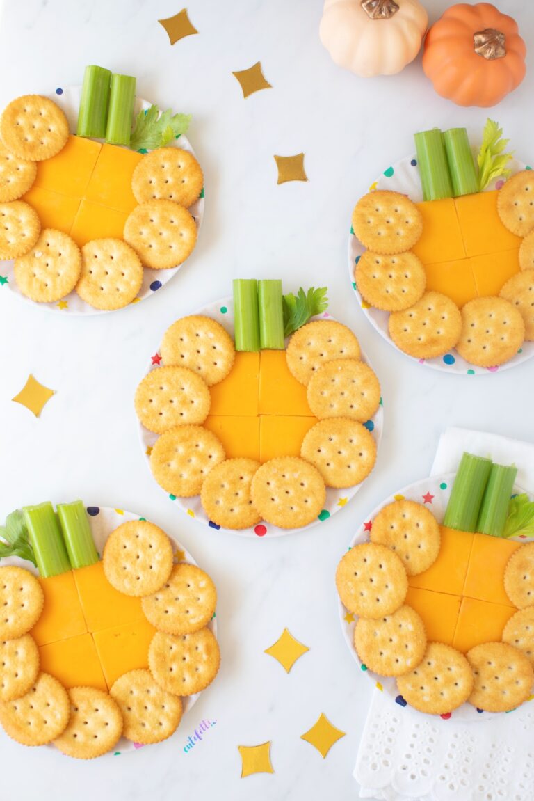 mini pumpkin cheese plates made with cracker cut cheddar cheese, crackers and celery.