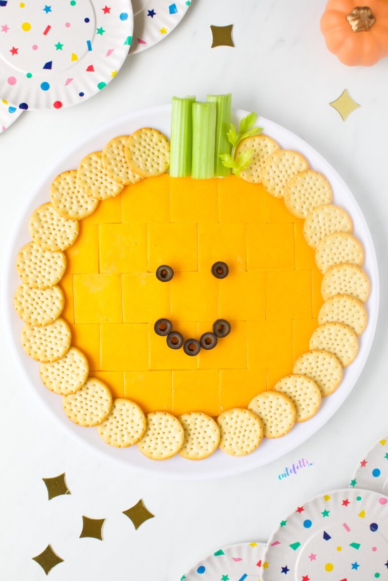 A mix of cheddar cracker cuts, crackers, celery, and black olives makes the pumpkin cheese tray extra fun.
