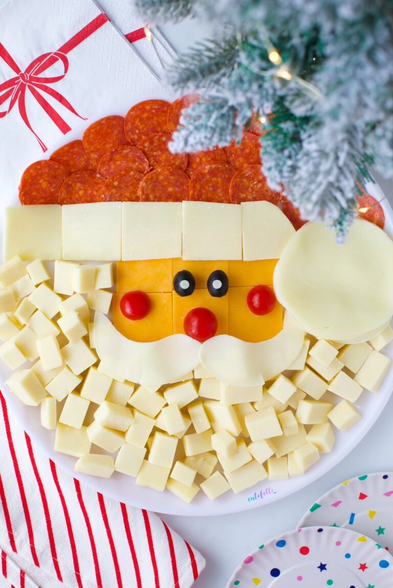 up close view of a santa clause snack platter with cheeses, pepperoni and veggies.