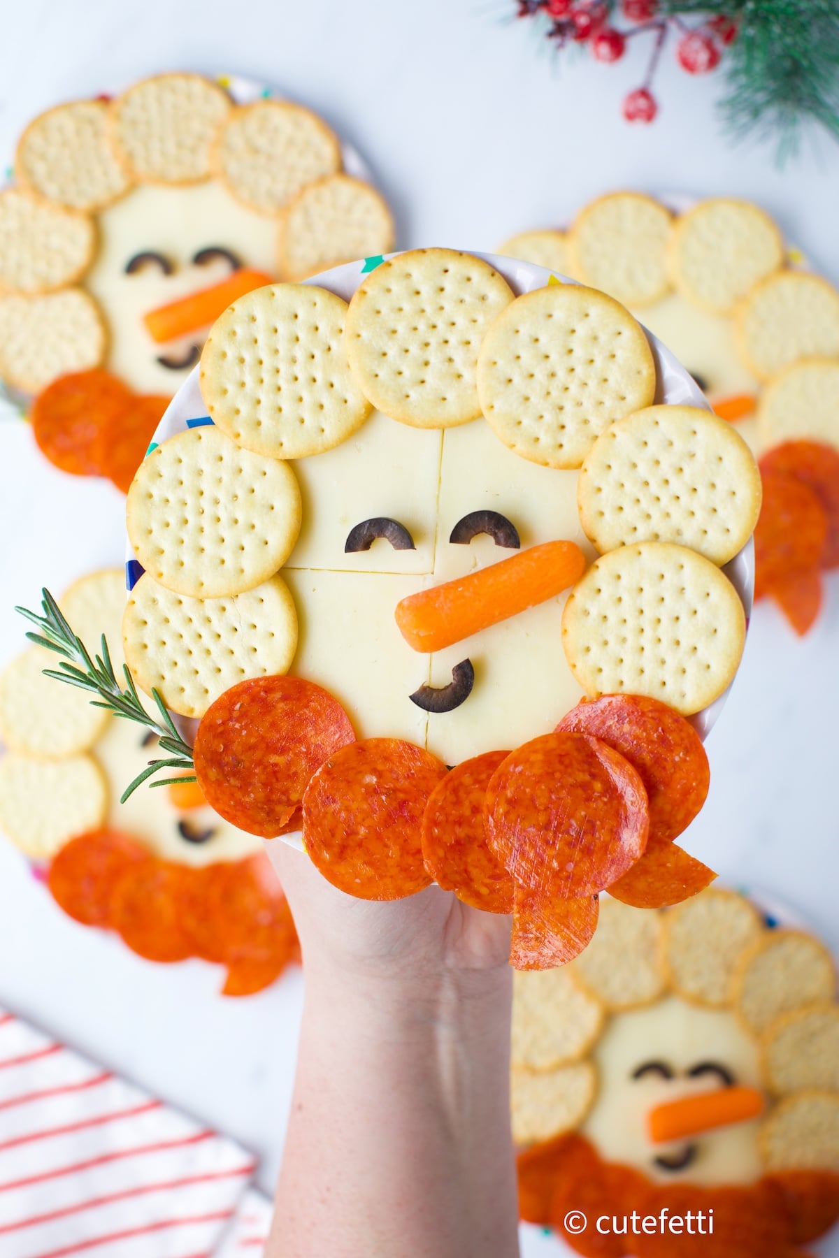 fun snowman snack plates made with cheese, crackers and pepperoni with a baby carrot for a nose.