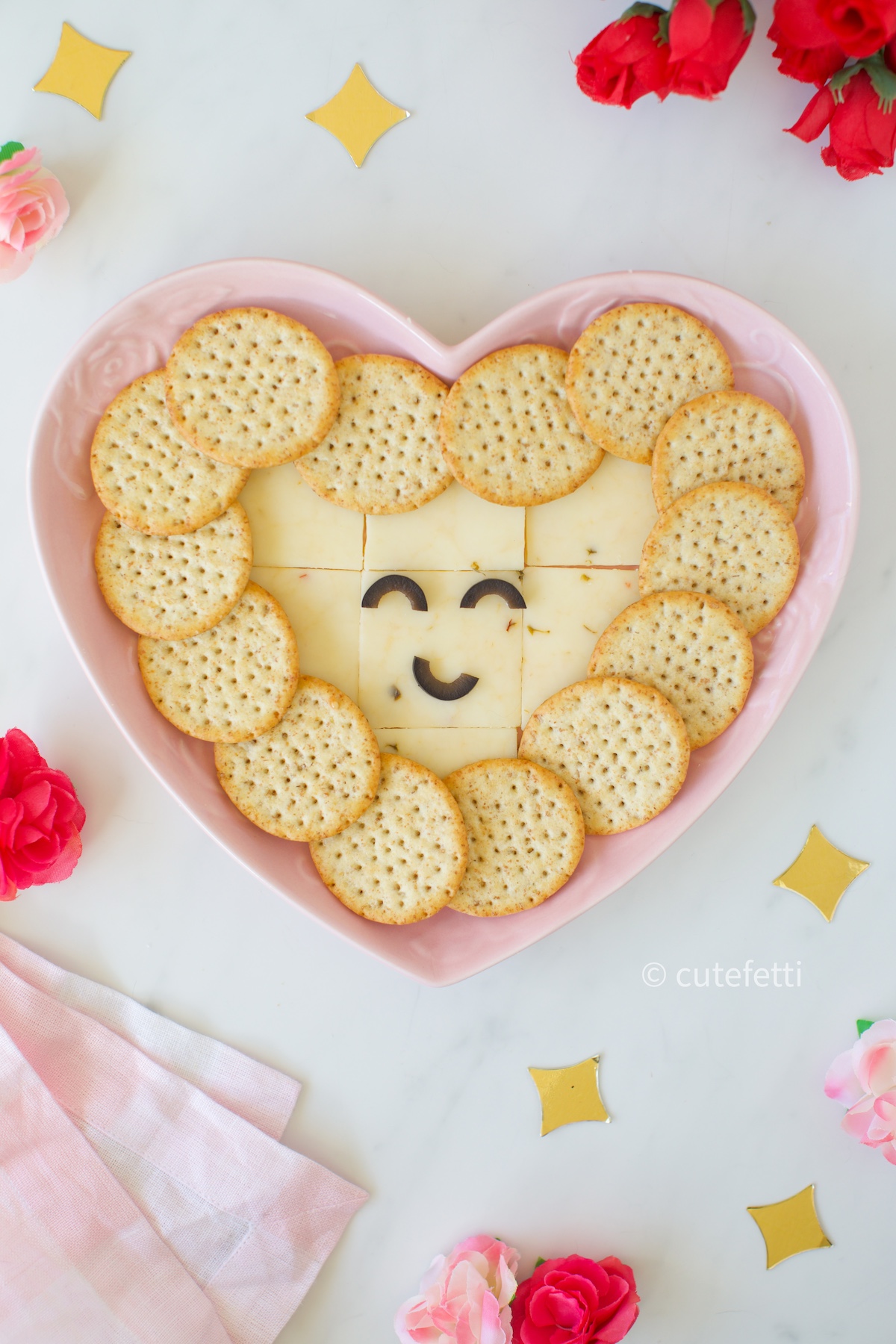 heart snack plate with a smiley face made with black olive slices.