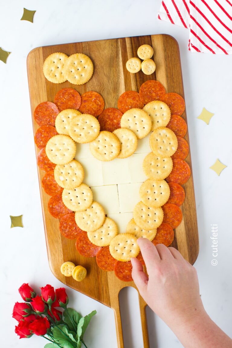 cute cheese and cracker board on a wooden cutting board.