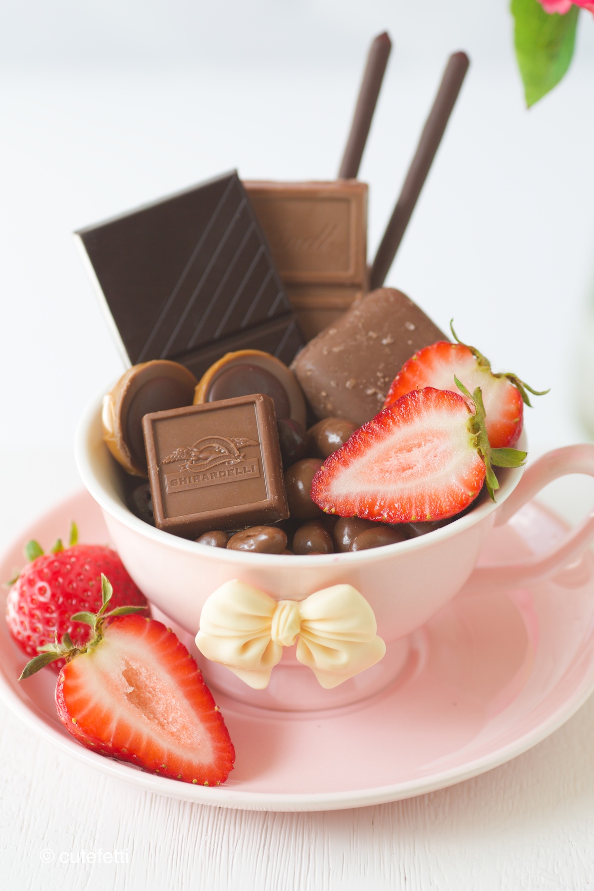chocolate snack cups with variety of treats and strawberry slices.
